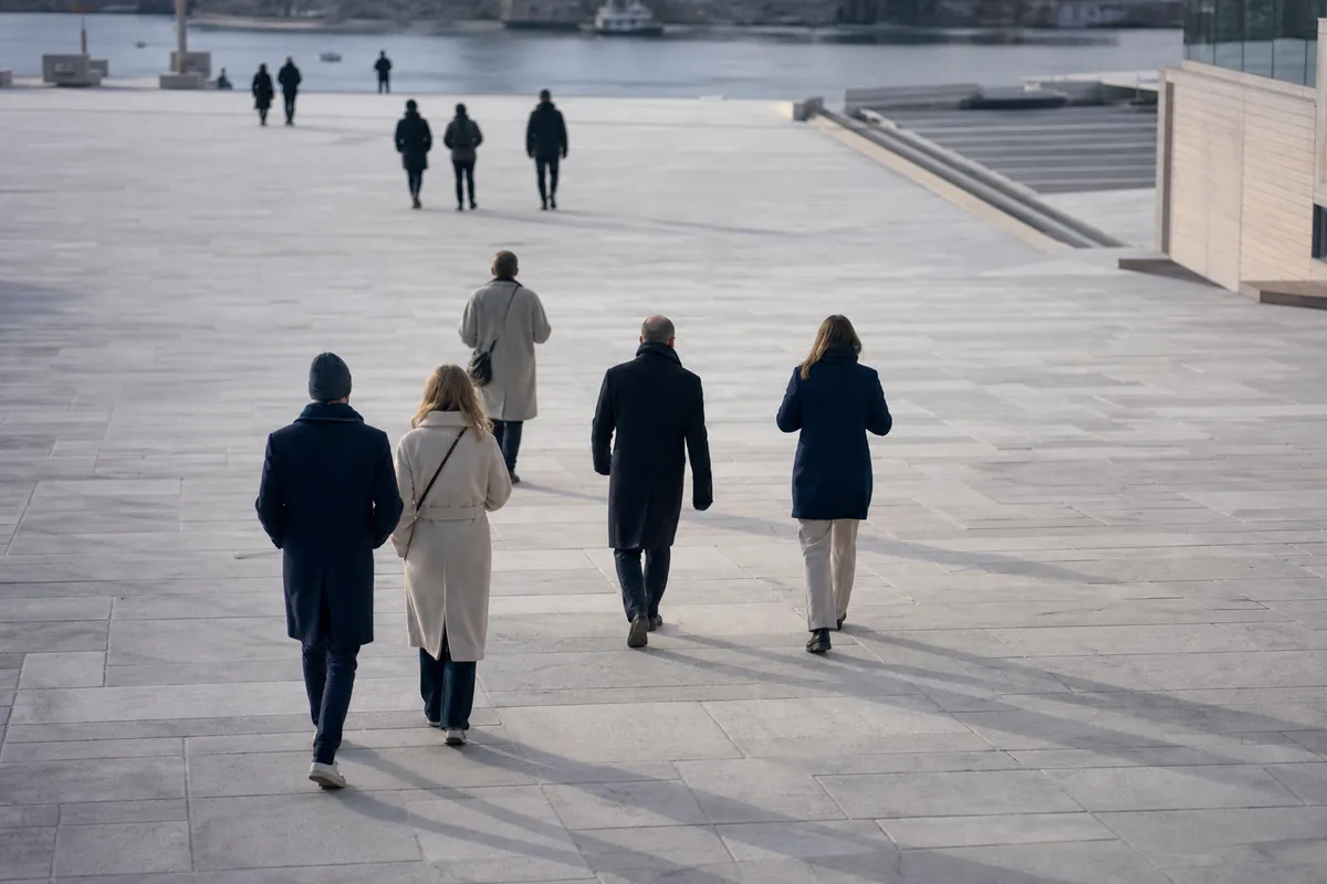 Människor på väg över ett stort torg sett snett uppifrån i dagsljus